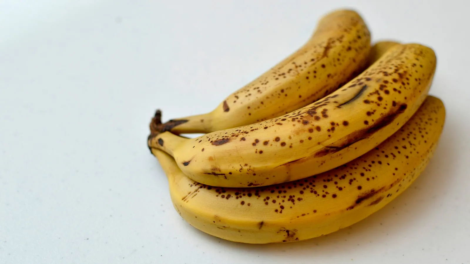A bunch of ripe bananas covered in brown spots